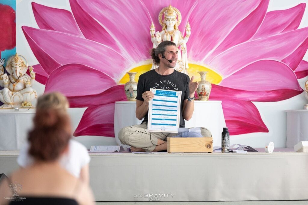 Marc Fenner unterrichtet vor einem Lotusmotiv beim Xperience Festival